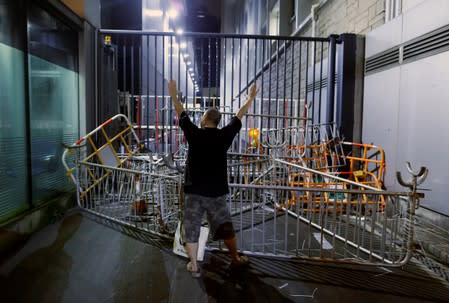 A protester stands in front of a barricade at the gate of the police headquarters after a rally ahead of the G20 summit in Hong Kong