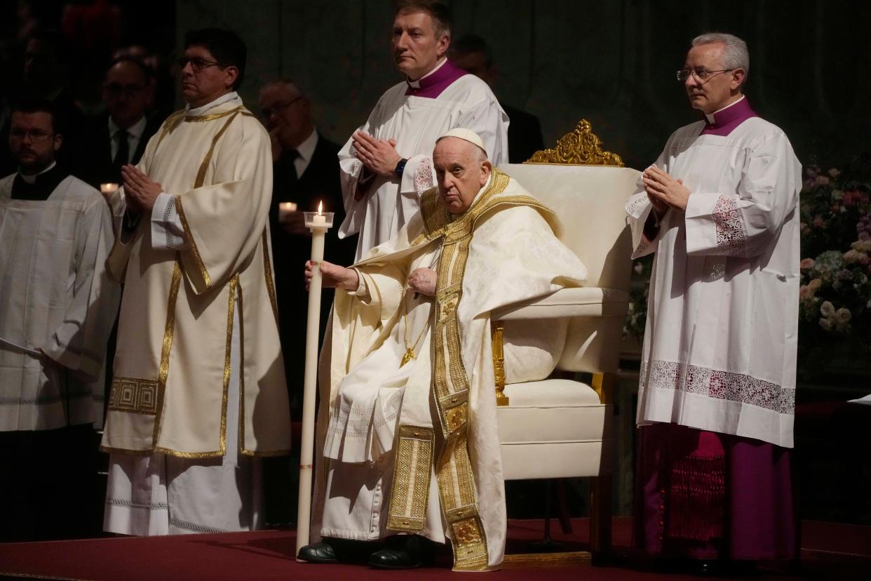 Pope Francis holds a Paschal candle as he presides over a Easter vigil ceremony on Saturday in St. Peter's Basilica at the Vatican.