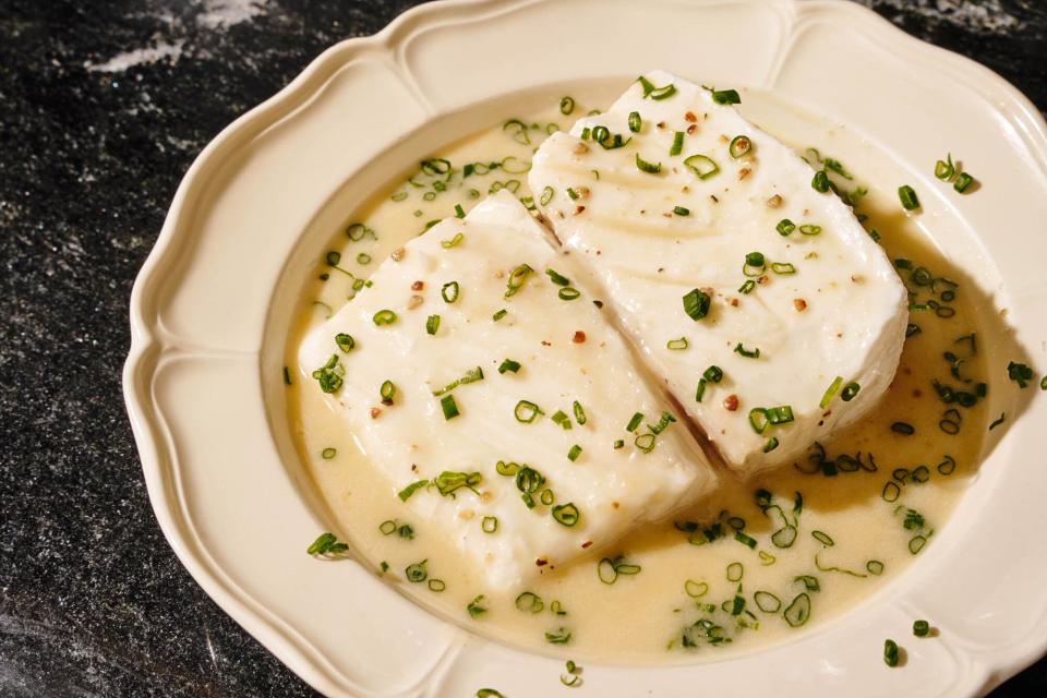 Poached halibut with butter sauce and thinly sliced chives