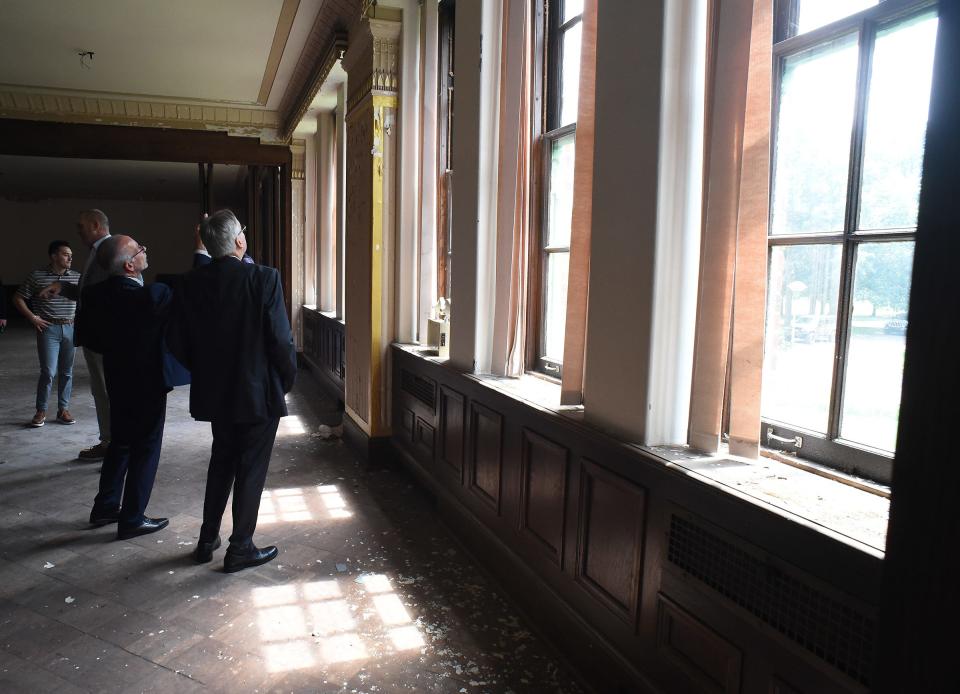 Officials from the city of Monroe and Monroe County, including Monroe Mayor Robert Clark and Monroe County Administrator Michael Bosanac, look into the windows of the old St. Louis building.