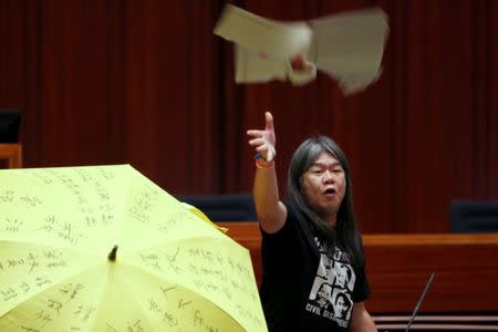 Re-elected lawmaker Leung Kwok-hung throws a torn placard while taking oath at the Legislative Council in Hong Kong, China October 12, 2016. REUTERS/Bobby Yip