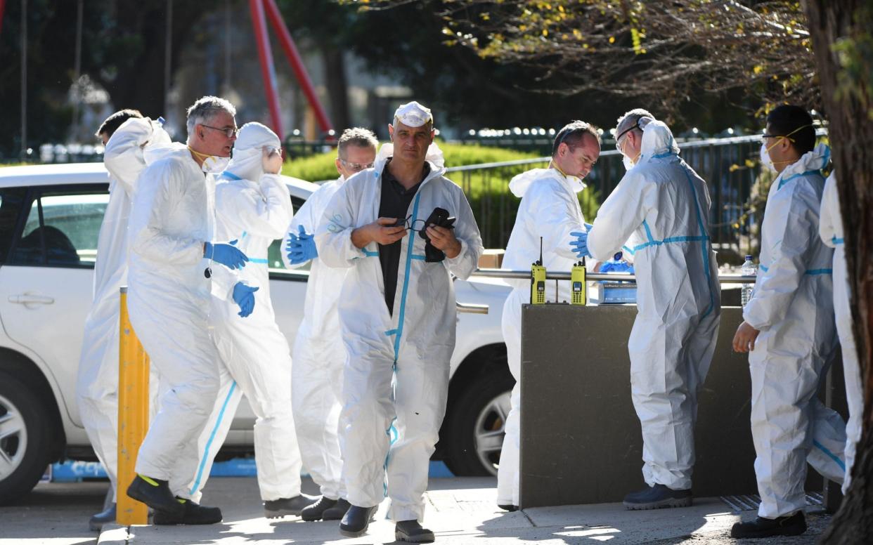 People wearing personal protective equipment congregate after entering a public housing tower in Flemington, Melbourne - JAMES ROSS/EPA-EFE/Shutterstock/Shutterstock