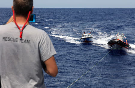 A lifeguard from the Spanish NGO Proactiva Open Arms aboard the former fishing trawler Golf Azzurro keeps an eye on a speed craft launched by the C Star vessel run by a group of anti-immigration activists in the Western Mediterranean Sea August 15, 2017. REUTERS/Yannis Behrakis