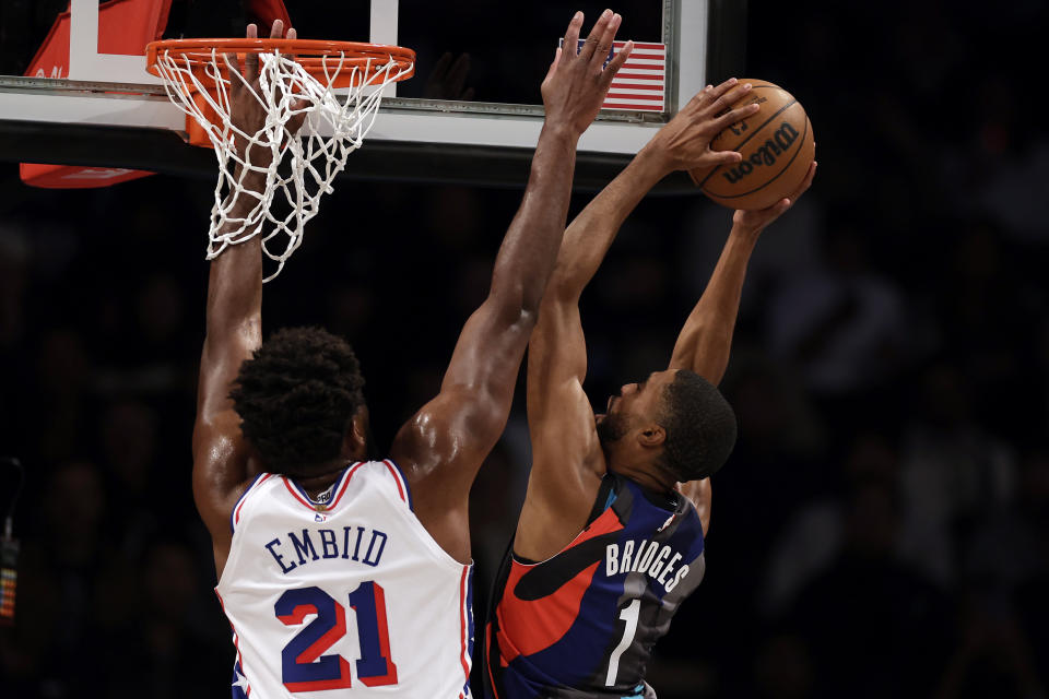 Brooklyn Nets forward Mikal Bridges drives to the basket against Philadelphia 76ers center Joel Embiid (21) during the first half of an NBA basketball game, Sunday, Nov. 19, 2023, in New York. (AP Photo/Adam Hunger)