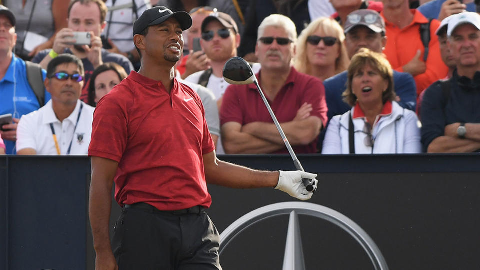 Woods sprays his drive off the 18th tee as a fan shouts out. Pic: Getty