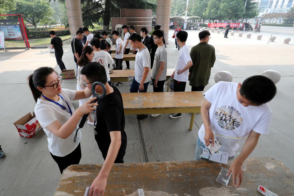 2 Students are checked with metal detectors as they enter the venue for the annual national college entrance examination, or "gaokao", in Lianyungang, Jiangsu province, China June 7, 2018.