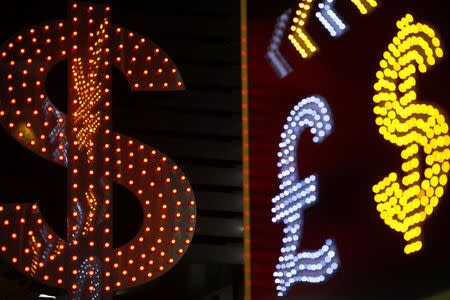 Dollar signs are seen alongside the signs for other currencies at a currency exchange shop in Hong Kong November 1, 2014. REUTERS/Damir Sagolj