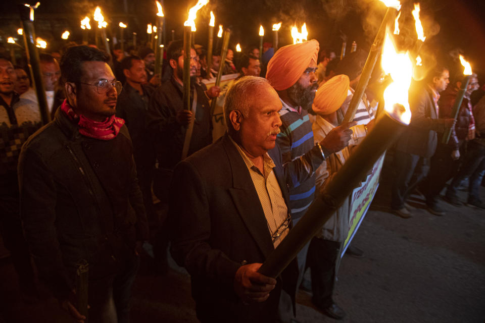 Indian protestors march in a torch light procession against the Citizenship Amendment act in Gauhati, India, Friday, Dec. 20, 2019. Police banned public gatherings in parts of the Indian capital and other cities for a third day Friday and cut internet services to try to stop growing protests against a new citizenship law that have left 11 people dead and more than 4,000 others detained. (AP Photo/Anupam Nath)