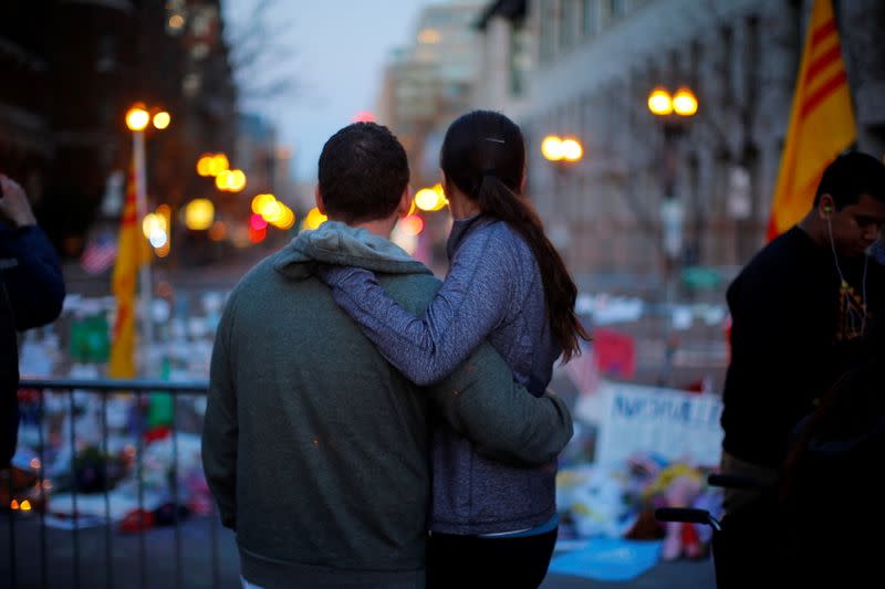 FILE PHOTO: A couple embraces at a memorial on Boylston Street to the victims of the Boston Marathon bombings in Boston