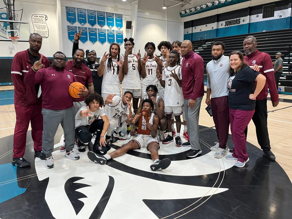 Lake Worth players, coaches and support staff pose with the District 8-7A championship trophy Saturday night at Royal Palm Beach High School.