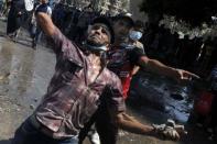 Egyptian protesters throw stones to the riot police during clashes near the US embassy in Cairo