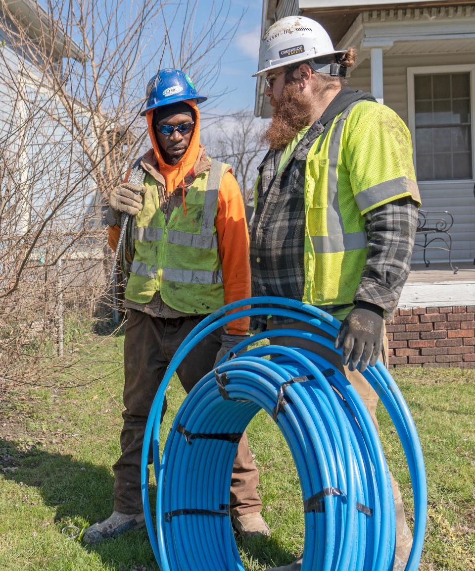 Foreman Andre Thompkins and Casey Graves with TSW Utility Solutions, Inc., gather new service lines as they work on the project with Citizens Energy replacing lead service lines into homes Thursday, March 28, 2024 on New York Street. Thousands of customers across Indianapolis will get new service lines free and now be protected from any possible lead getting into their water from their pipes.
