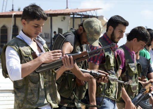 Volunteers for the Amr Ibn Al-Aass brigade load their rifles during training on the outskirts of Azaz, in northern Syria. Syrian rebels seized a crossing on the Turkish border Wednesday even as they quit a swathe of south Damascus that activists said had been reduced to a disaster area by weeks of heavy fighting