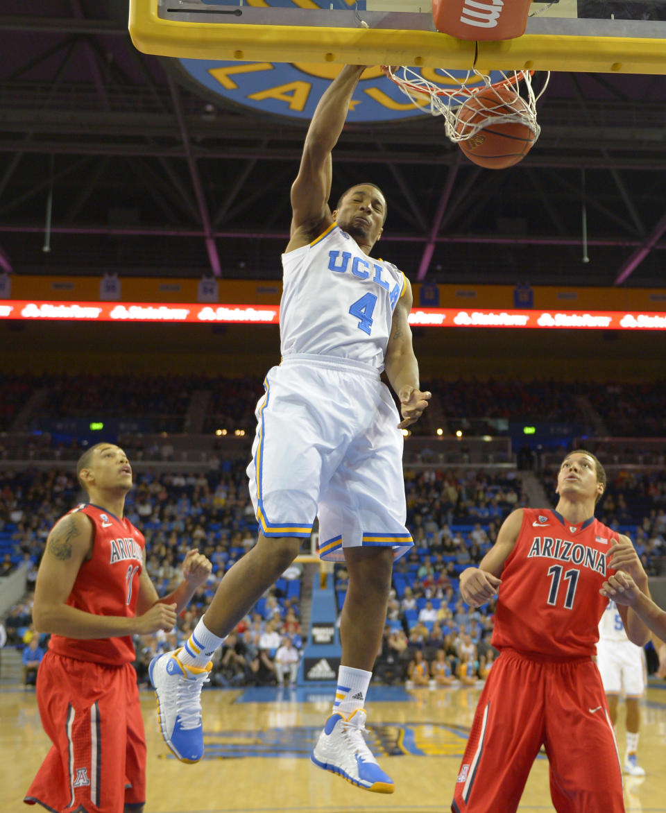 UCLA guard Norman Powell (4) dunks as Arizona forward Brandon Ashley, left, and forward Aaron Gordon defend during the first half of an NCAA college basketball game on Thursday, Jan. 9, 2014, in Los Angeles. (AP Photo/Mark J. Terrill)