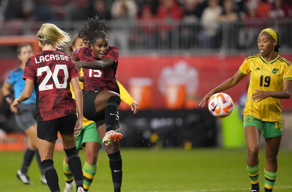 Canada's Nichelle Prince, centre, moves the ball up field as Jamaica's Timmy Wiltshire, right, looks on during the first half.