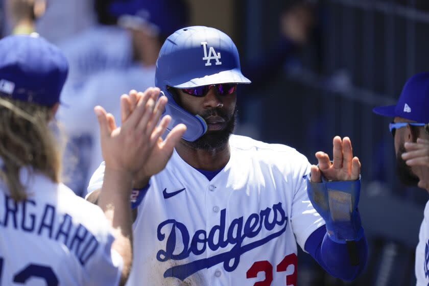 Los Angeles Dodgers' Jason Heyward (23) celebrates in the dugout after scoring off of a sacrifice fly.