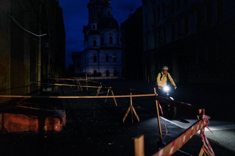 Cyclist on the street of Kharkiv, Ukraine, on April 21, 2024, amid a blackout due to the Russian attacks on energy infrastructure. (Serhii Korovayny/The Kyiv Independent)