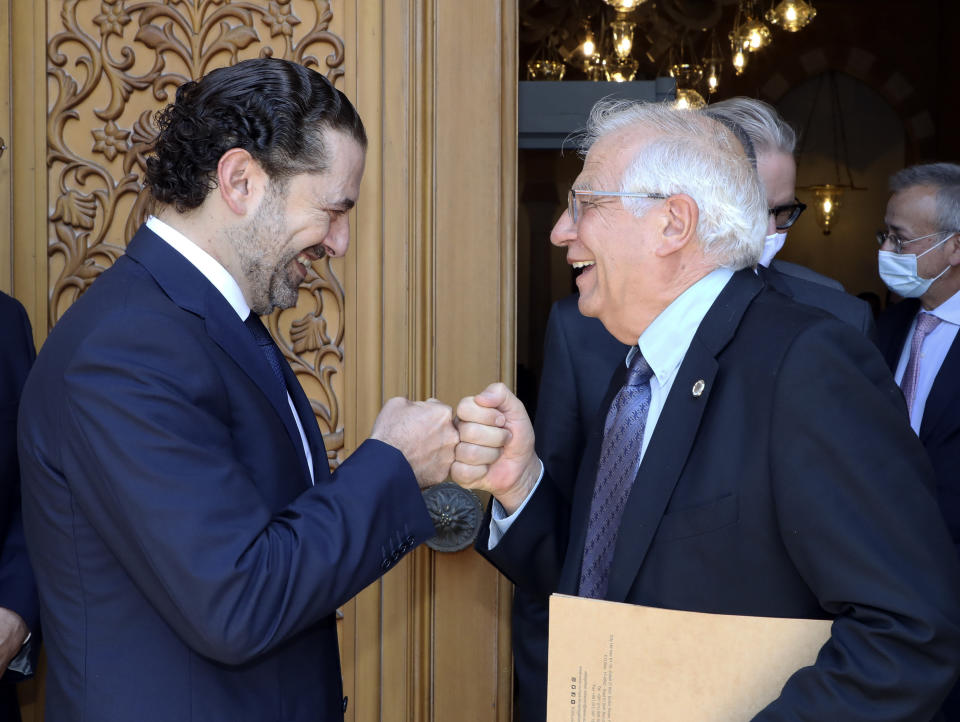 In this photo released by Lebanese government, Lebanese Prime Minister-Designate Saad Hariri, left, greets European Union foreign policy chief Josep Borrell with a fist bump, in Beirut, Lebanon, Saturday, June. 19, 2021. Borrell berated Lebanese politicians for delays in forming a new Cabinet, warning the union could impose sanctions on those behind the political stalemate in the crisis-hit country. (Dalati Nohra/Lebanese Official Government via AP)