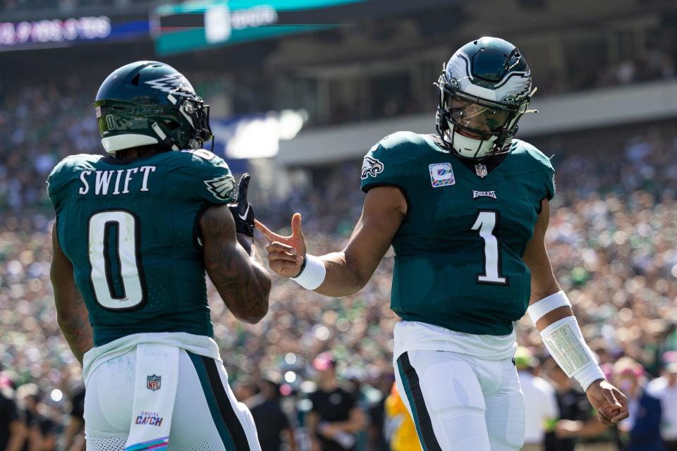 Philadelphia Eagles running back D'Andre Swift (0) celebrates with quarterback Jalen Hurts (1) after his touchdown run against the Washington Commanders during the first quarter at Lincoln Financial Field.