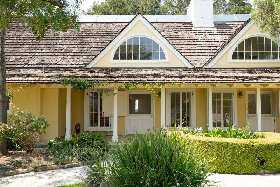 The main house is painted a sunny yellow.