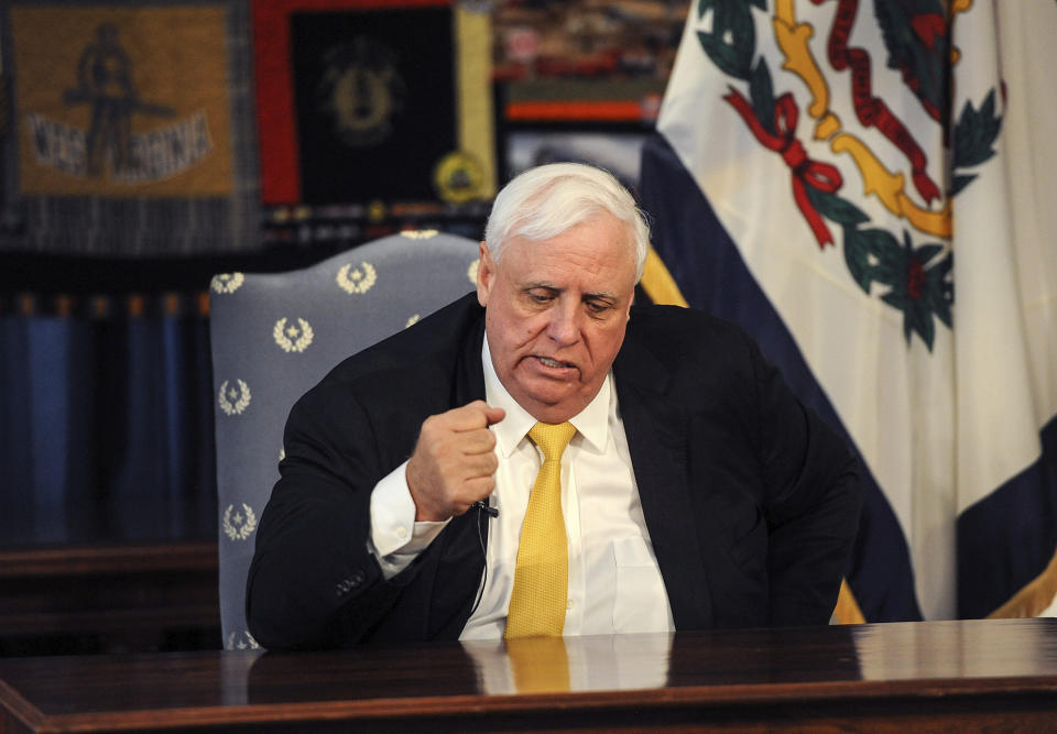 West Virginia Gov. Jim Justice pounds the table at the conclusion of his press conference saying the state can beat the coronavirus challenge, Friday, March 13, 2020 at the state Capitol in Charleston, W.Va. Justice announced that all schools are to be closed by the end of the school day Friday. (Chris Dorst/Charleston Gazette-Mail via AP)