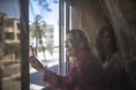 Afifa, 61, shows the empty streets as she makes a video call with her relatives on the first day of Eid in lockdown due to the Coronavirus pandemic, in Casablanca, Morocco, Sunday, May 24, 2020. (AP Photo/Mosa'ab Elshamy)