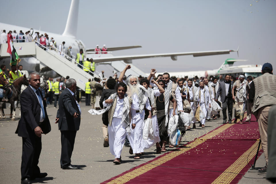 Yemeni prisoners chant slogans during their arrival after being released by the Saudi-led coalition at the airport in Sanaa, Yemen, Friday, Oct. 16, 2020. Yemen's warring sides completed a major, U.N.-brokered prisoner swap on Friday, officials said, a development that could revive the country's stalled peace process after more than five years of grinding conflict. (AP Photo/Hani Mohammed)