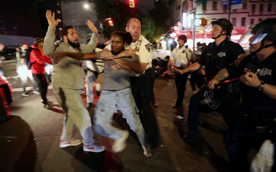 NYPD officers arrest a protester continued to flout curfew restrictions was in effect from 8 pm on Tuesday - Anadolu