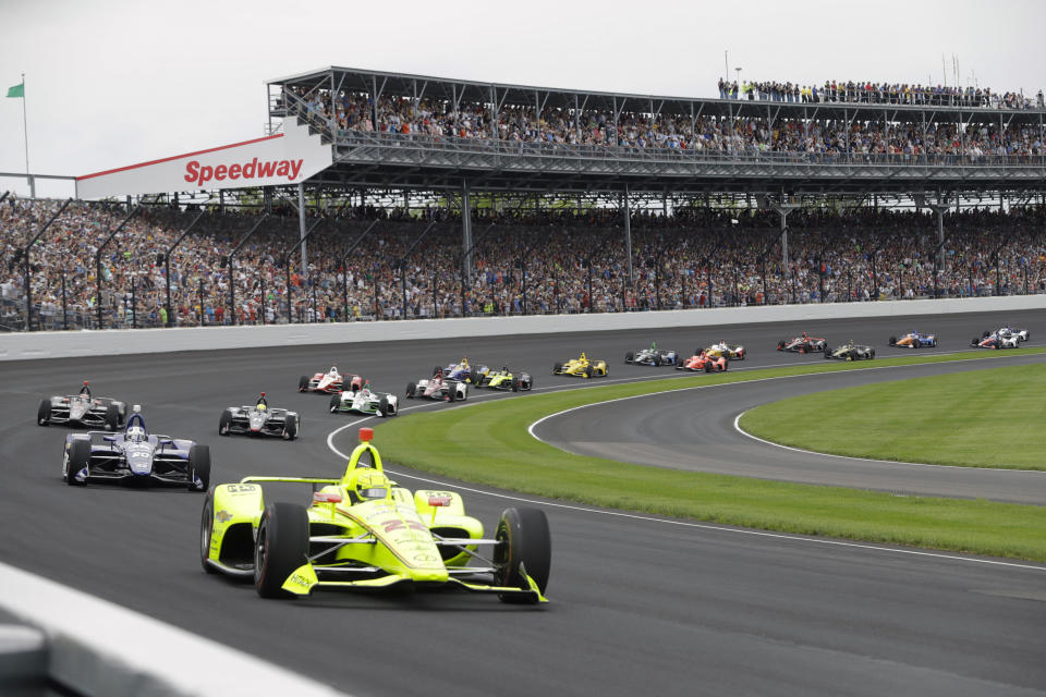 FILE - In this May 26, 2019, file photo, Simon Pagenaud, of France, leads the field through the first turn on the start of the Indianapolis 500 IndyCar auto race at Indianapolis Motor Speedway in Indianapolis. The Indianapolis 500 will be the largest sporting event since the start of the pandemic with 135,000 spectators permitted to attend “The Greatest Spectacle in Racing” next month. Indianapolis Motor Speedway said Wednesday, April 21, 2021, it worked with the Marion County Public Health Department to determine 40% of venue capacity can attend the May 30 race. (AP Photo/Darron Cummings, File)