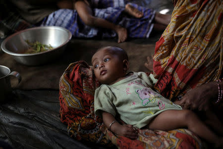 A Rohingya Hindu refugee woman holds her child inside their temporary shelter at the Kutupalong Hindu refugee camp near Cox's Bazar, Bangladesh December 17, 2017. REUTERS/Marko Djurica