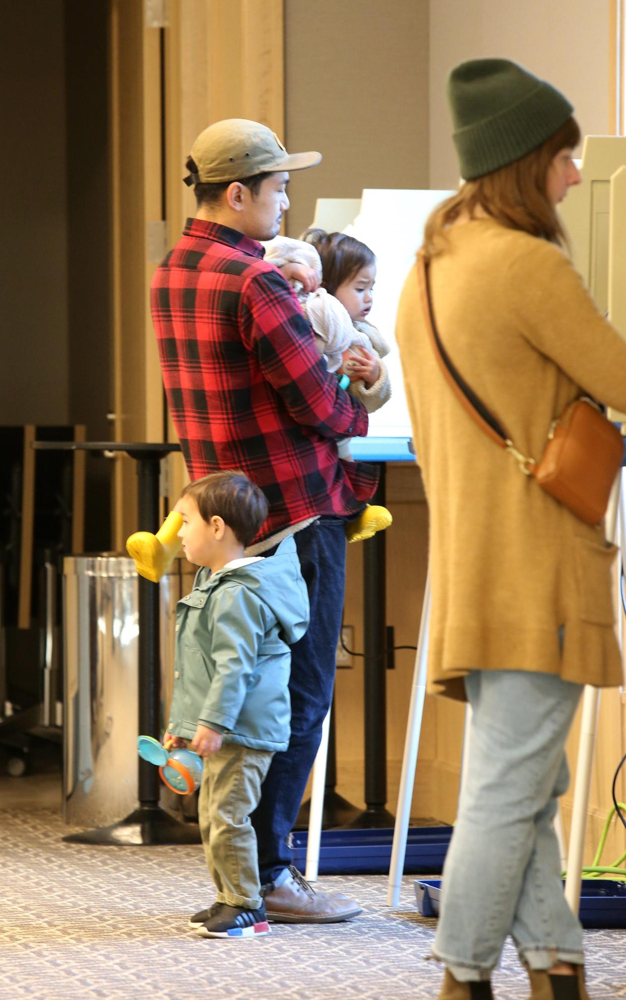 Brian Guinto of South Bend holds his daughter, Maisie, 1, as his son, Amos, 3, stands by as Brian and Laura Guinto vote Tuesday, Nov. 8, 2022, at the St. Joseph County Public Library voting center in the ballroom. Voters in Indiana have the chance to vote until 6 p.m..