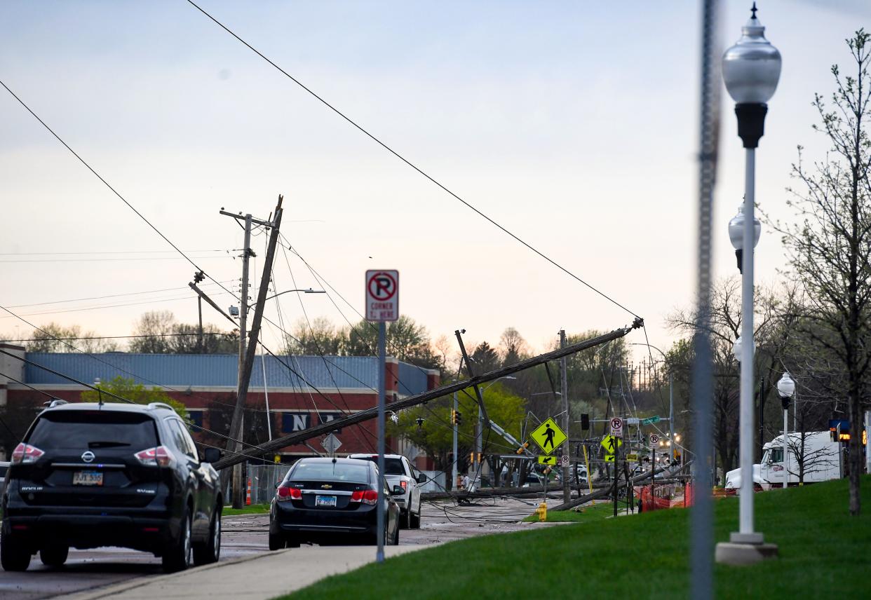 Live power lines and electricity poles fall into the street on Augustana University's campus on Thursday, May 12, 2022, in Sioux Falls.