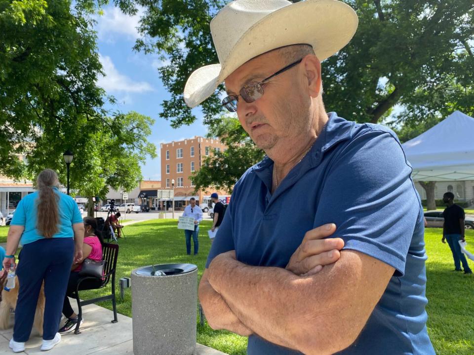 A man reads messages on white crosses.