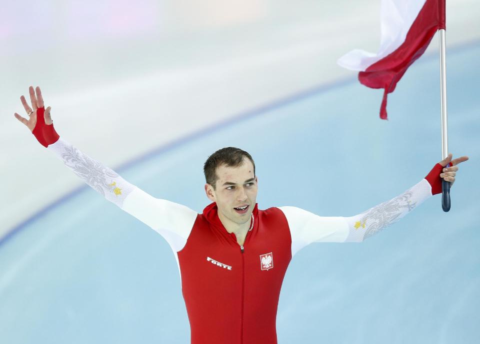 Gold medallist Poland's Zbigniew Brodka holds his national flag and celebrates after the men's 1,500-meter speedskating race at the Adler Arena Skating Center during the 2014 Winter Olympics in in Sochi, Russia, Saturday, Feb. 15, 2014. (AP Photo/Pavel Golovkin)