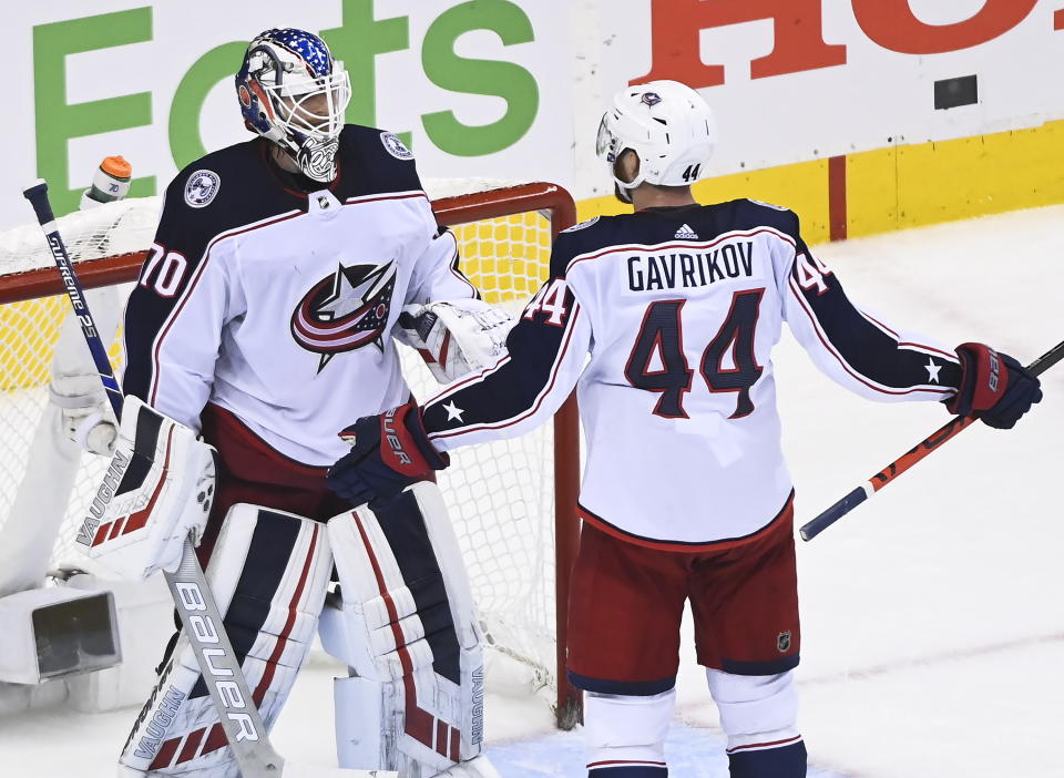 Columbus Blue Jackets goaltender Joonas Korpisalo (70) celebrates with Vladislav Gavrikov (44) after the Blue Jackets defeated the Toronto Maple Leafs in NHL hockey playoff game Sunday, Aug. 9, 2020, in Toronto. The Blue Jackets advanced in the playoffs. (Nathan Denette/The Canadian Press via AP)