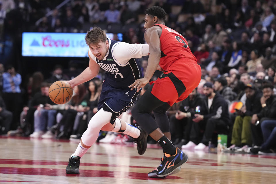 Dallas Mavericks' Luka Doncic drives at Toronto Raptors' RJ Barrett during the second half of an NBA basketball game in Toronto on Wednesday, Feb. 28, 2024. (Chris Young/The Canadian Press via AP)