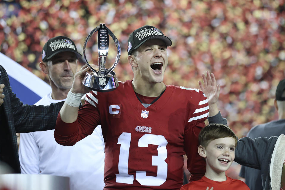 San Francisco 49ers quarterback Brock Purdy (13) and head coach Kyle Shanahan, left, celebrate after the NFC Championship NFL football game against the Detroit Lions in Santa Clara, Calif., Sunday, Jan. 28, 2024. (AP Photo/Jed Jacobsohn)