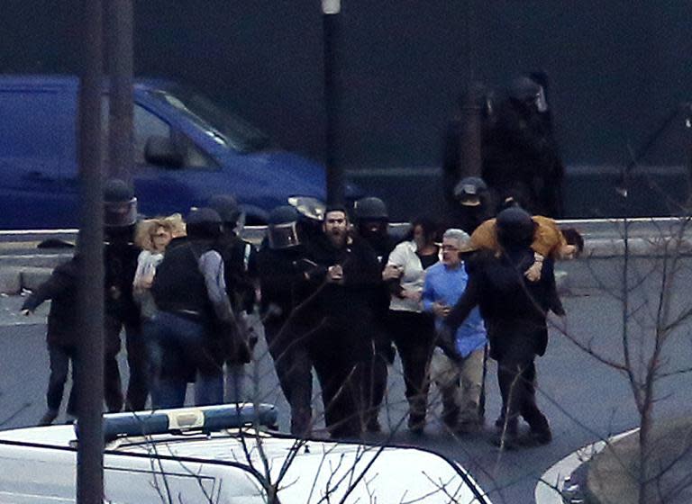 French police special forces evacuate hostages after launching an assault at a kosher grocery store in Porte de Vincennes, eastern Paris