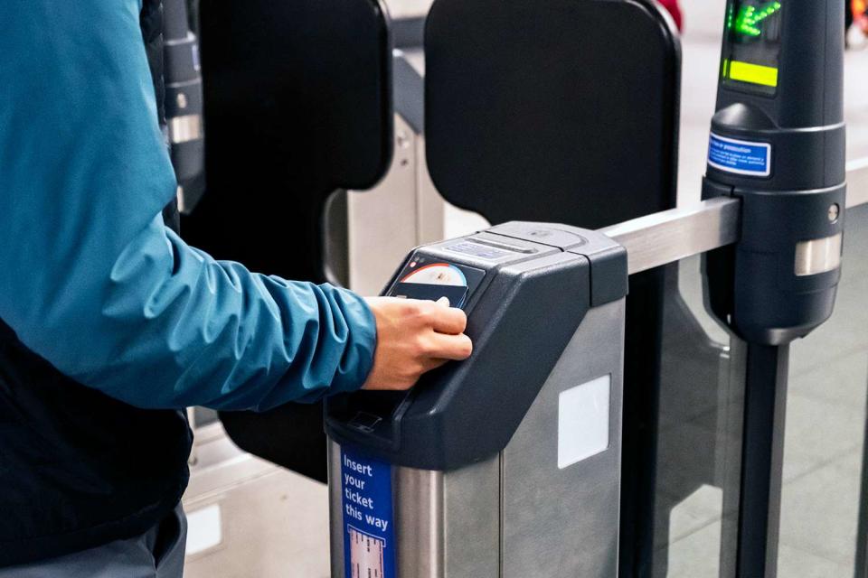 <p>Artur Debat/Getty</p> Man pays for his fare on the London Underground