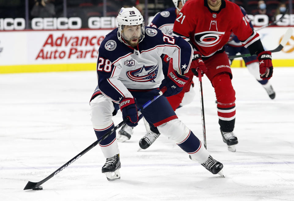 FILE - In this May 1, 2021, file photo, Columbus Blue Jackets' Oliver Bjorkstrand (28) moves the puck against the Carolina Hurricanes during the first period of an NHL hockey game in Raleigh, N.C. It is clear from recent signings who will form the core of the retooled Blue Jackets. Forwards Boone Jenner and Bjorkstrand are inked through the 2025-26 season, defenseman Zach Werenski is locked up through 2026-27, and last week goaltender Elvis Merzlikins signed an extension through ‘26-’27. (AP Photo/Karl B DeBlaker, File)