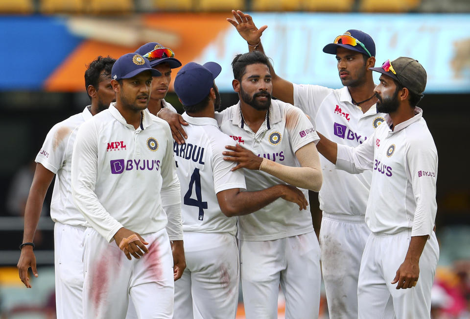 India's Mohammed Siraj, centre, is congratulated by teammates after taking his fifth wicket during play on day four of the fourth cricket test between India and Australia at the Gabba, Brisbane, Australia, Monday, Jan. 18, 2021. (AP Photo/Tertius Pickard)