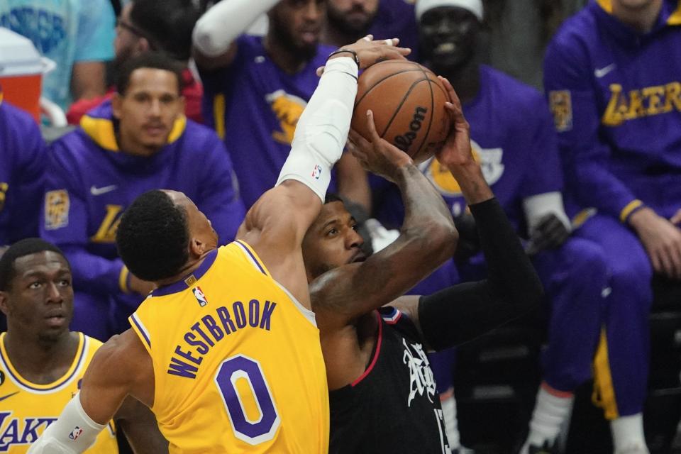 Los Angeles Clippers guard Paul George, right, shoots as Los Angeles Lakers guard Russell Westbrook defends during the first half of an NBA basketball game Wednesday, Nov. 9, 2022, in Los Angeles. (AP Photo/Mark J. Terrill)