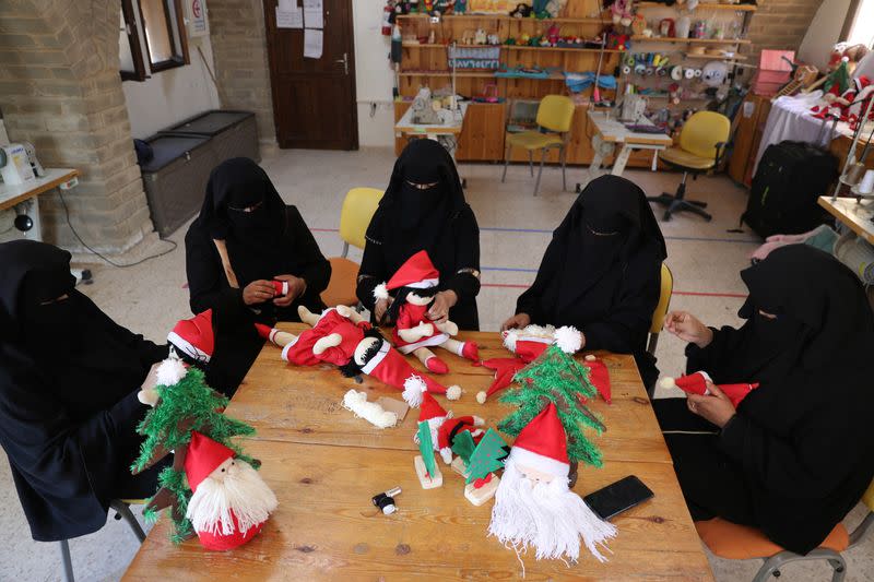 Palestinian women wearing face veil, niqab, make Santa-themed Christmas toys in the northern Gaza Strip