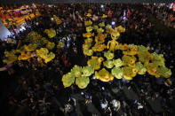 Inflatable yellow ducks, which have become good-humored symbols of resistance during anti-government rallies, are lifted over a crowd of protesters Friday, Nov. 27, 2020 in Bangkok, Thailand. Pro-democracy demonstrators are continuing their protests calling for the government to step down and reforms to the constitution and the monarchy, despite legal charges being filed against them and the possibility of violence from their opponents or a military crackdown. (AP Photo/Sakchai Lalit)