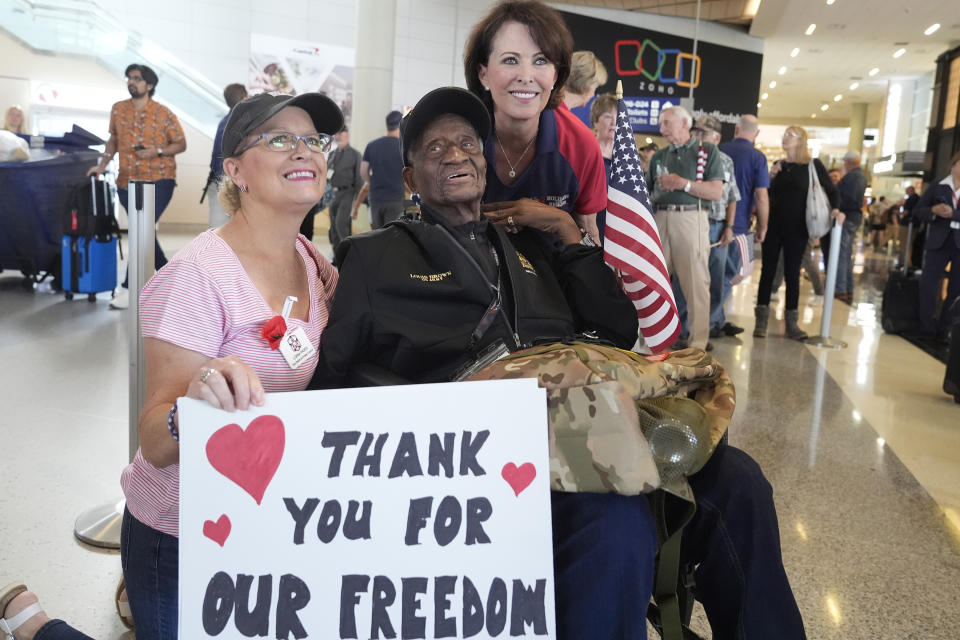 World War II veteran Louis Brown, center, poses for photos with Lorna Paden, left, and Kerre Randel before heading to board a flight with other veterans at Dallas Fort Worth International Airport in Dallas Friday, May 31, 2024. A group of World War II veterans are being flown from Texas to France where they will take part in ceremonies marking the 80th anniversary of D-Day. (AP Photo/LM Otero)