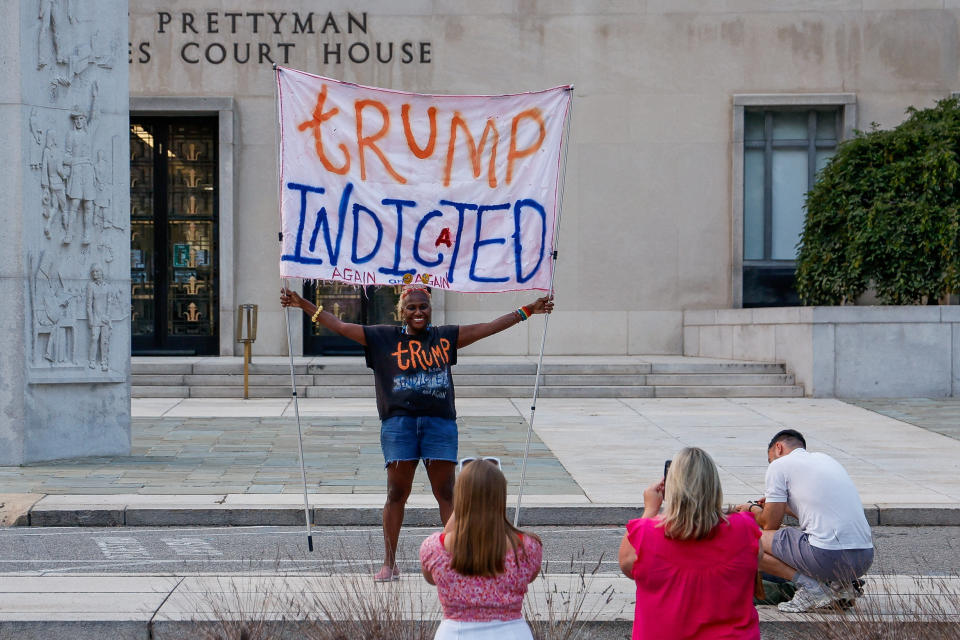 Nadine Seiler holds a banner in front of the federal courthouse in Washington, D.C., where Trump is expected to answer charges regarding his alleged attempt to overturn his 2020 election defeat