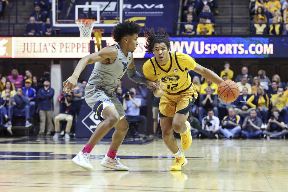 Missouri guard Dru Smith (12) drives it up court as he is defended by West Virginia guard Miles McBride (4) during the first half of an NCAA college basketball game Saturday, Jan. 25, 2020, in Morgantown, W.Va. (AP Photo/Kathleen Batten)