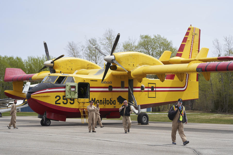 Firefighters arrive at the Flin Flon airport, as wildfires burn in northern Manitoba on Tuesday, May 14, 2024. (David Lipnowski/The Canadian Press via AP)