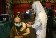 A government employee receives the Convidecia COVID-19 vaccine from a paramedic at a vaccination center in Nishtar hall, in Peshawar, Pakistan, Friday, June11, 2021. (AP Photo/Muhammad Sajjad)