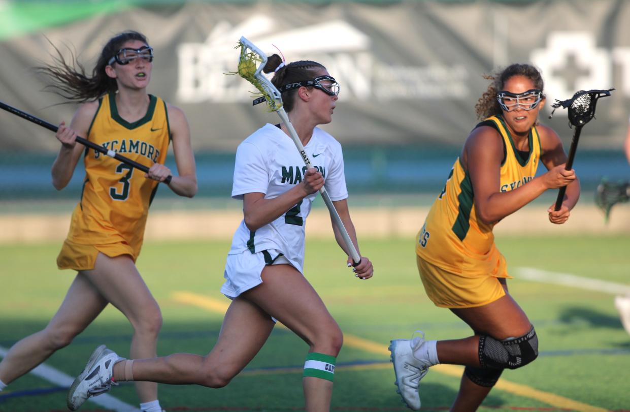 Sycamore seniors Emmi Bennett (3) and Paige Harris (30) try to defend Mason senior Claire Baenziger (2) as Sycamore defeated Mason 16-3 Thursday.